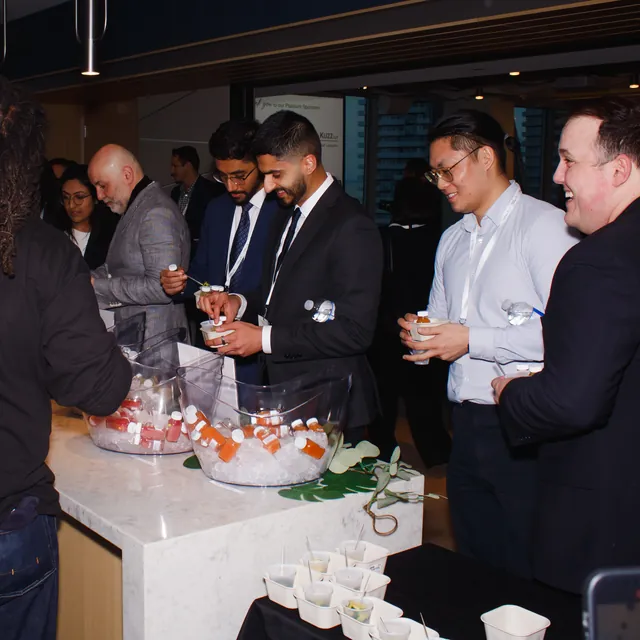 Guests talking around a refreshment table at a business event