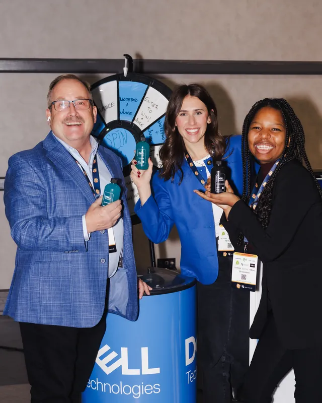 Three attendees smiling together at a business event
